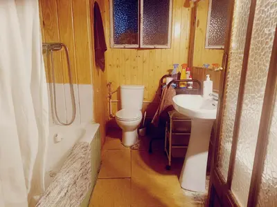 Un baño de habitación de 2 camas con 2 ventanas al exterior y TV en casa compartida